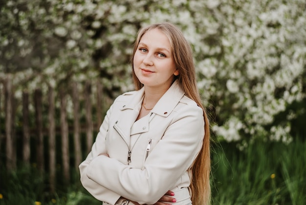 a girl in white in a blooming garden cherry blossoms a girl with long hair young girl