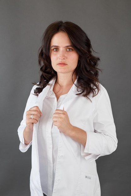 Girl in a white coat on a dark background