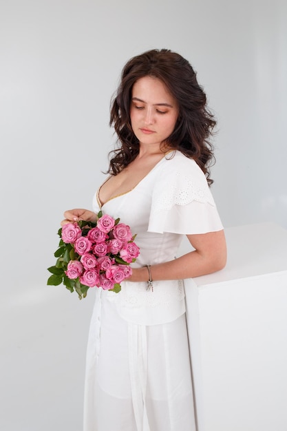 Girl in a white dress with a bouquet of flowers