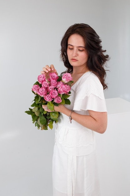 Girl in a white dress with a bouquet of flowers