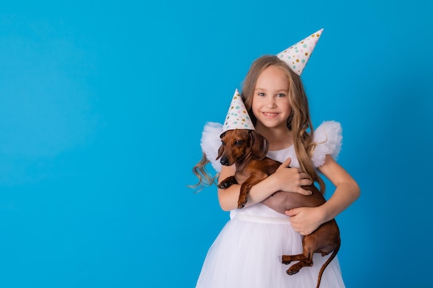 girl in a white fluffy elegant dress with a dachshund dog in her arms