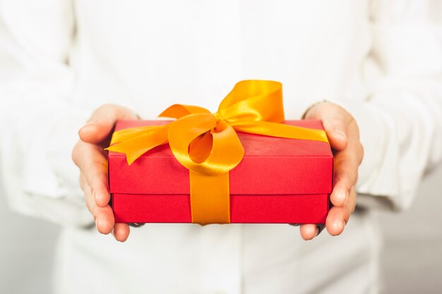 girl in a white shirt holds a gift.