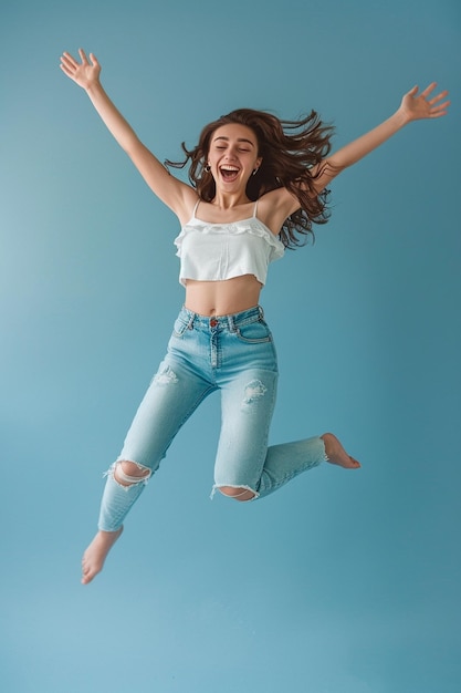 a girl in a white top is jumping in the air with her arms outstretched