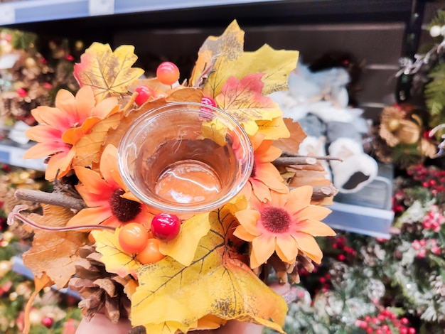 The girl who is in the mall holds a wreath made of autumn leaves