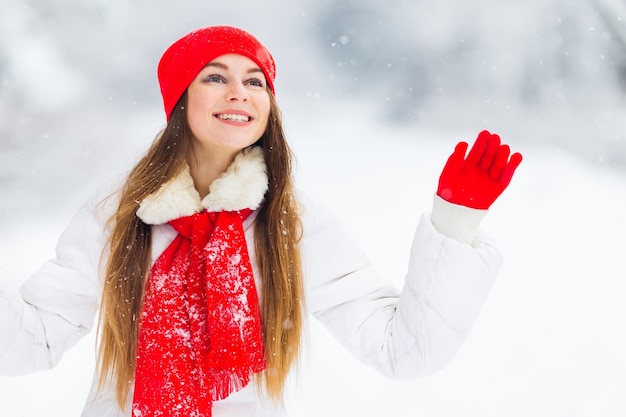 Girl in winter clothes with beautiful makeup waving her hand