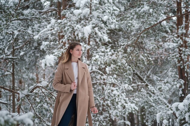 girl in winter forest with white trees and abundant snow