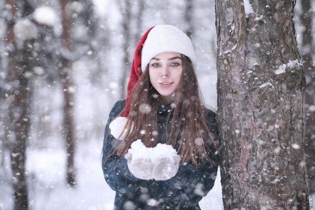 Girl in a winter park in the afternoon in snowfall