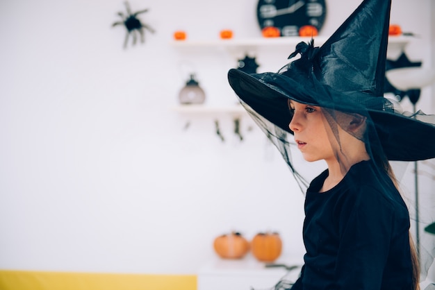 Girl in Witch costume contemplating