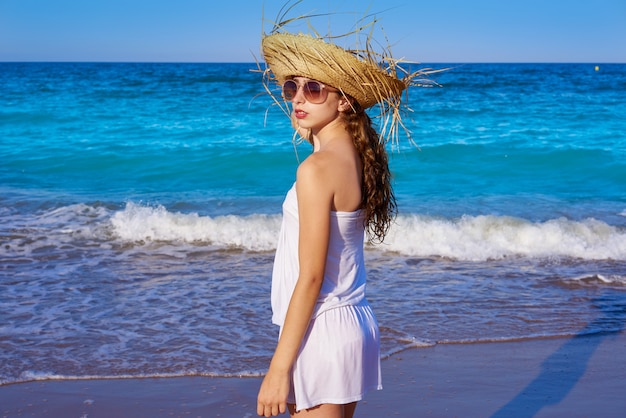 Girl with beach hat in sea shore profile