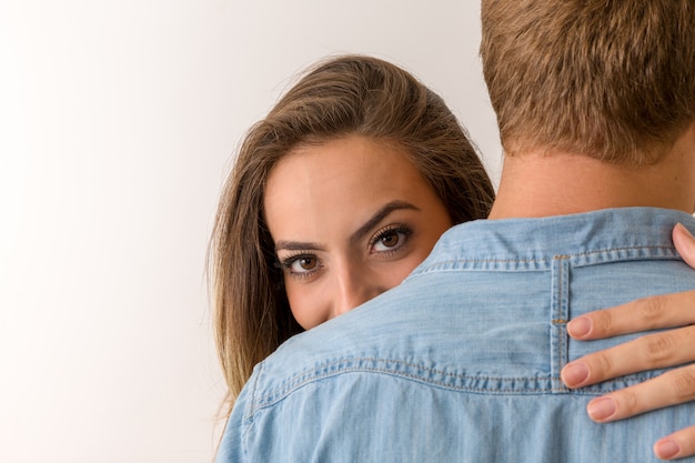 Girl with beautiful eyes hugs boy. Happy lovers.