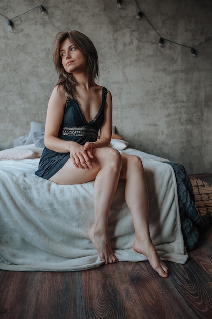 Girl with beautiful legs sitting on the bed