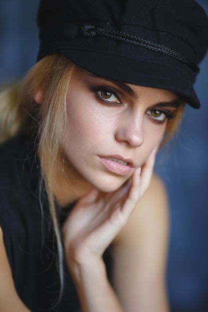 A girl with big eyes in a black fashion hat. A large portrait