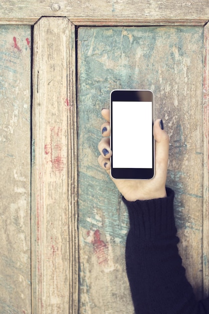 Girl with blank cell phone on a vintage wooden background