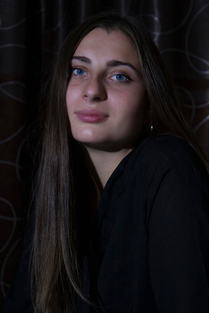 A girl with blue eyes on a dark background