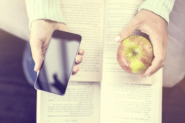 Girl with books smartphone and apple