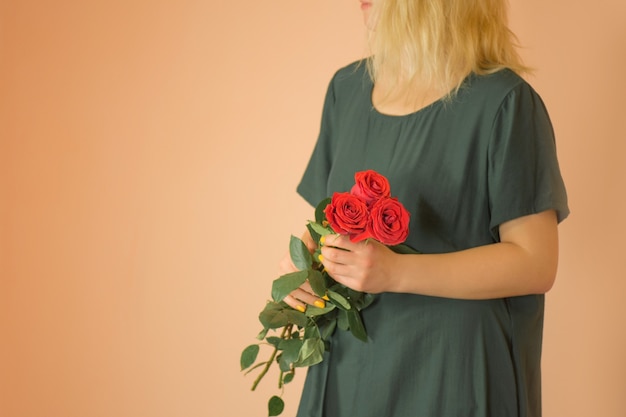 Girl with bouquet of red roses. Spring bouquet of red roses in woman's hands