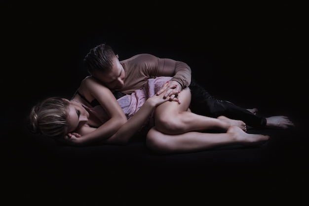 Girl with boyfriend perform beautiful gymnastic elements. 
beautiful acrobatic couple. black background