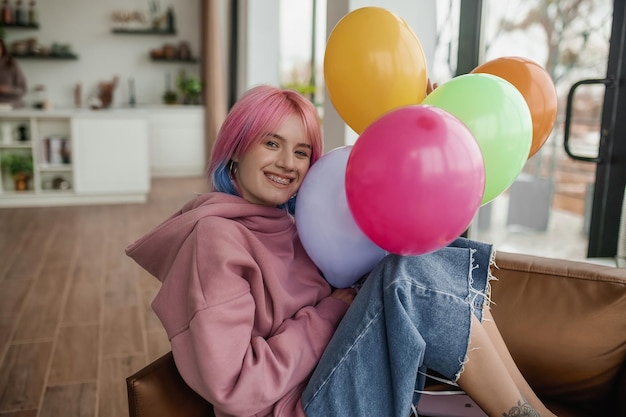 A girl with bright balloons feeling happy and joyful