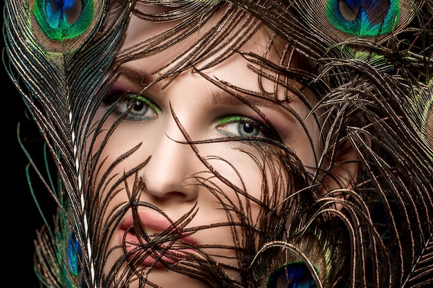 Girl with bright  makeup and peacock feathe