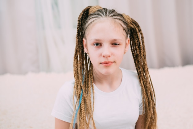 Girl with brown hair and pigtails braided with artificial hair