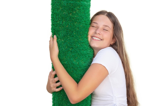 Girl with closed eyes hugging a roll of artificial grass Soft touch of an artificial turf sheet