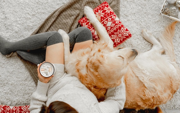 Girl with cocoa and golden retriever dog