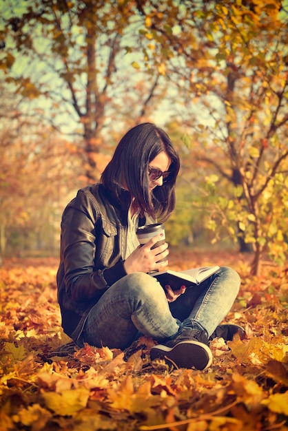 Girl with coffee cup reading a book