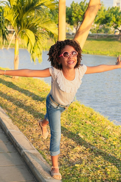 Girl with curly hair having fun playing in park