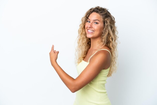 Girl with curly hair isolated on white background pointing back