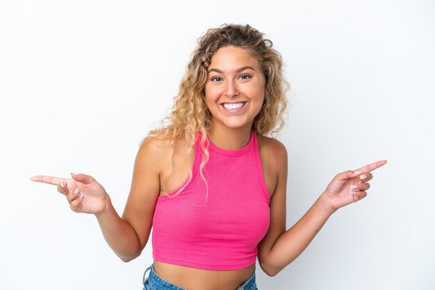 Girl with curly hair isolated on white background pointing finger to the laterals and happy