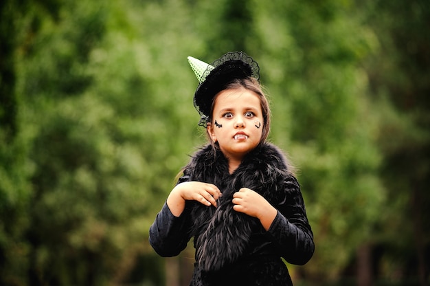 Girl with curly hair in a witch costume for Halloween