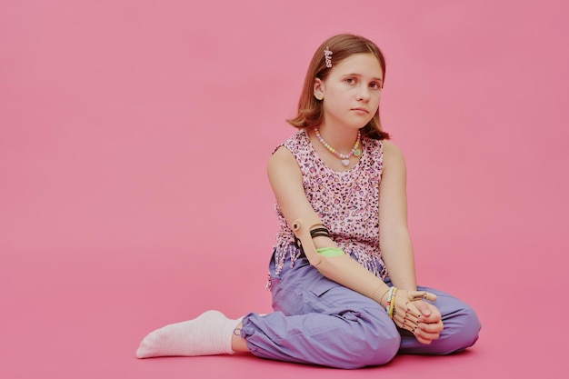 Photo girl with disability sitting relaxed on floor