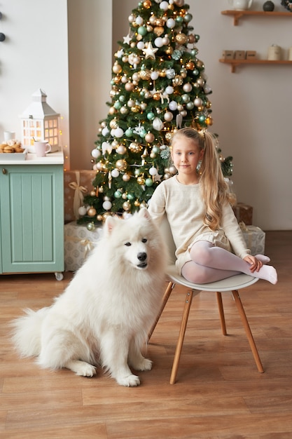 girl with a dog near the Christmas tree on the Christmas background