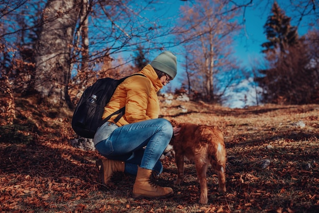 Girl with a dog play in the mountains. Autumn mood. Traveling with a pet.Woman and her dog posing outdoor.