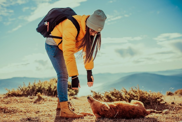 Girl with a dog play in the mountains autumn mood traveling with a petwoman and her dog posing outdo