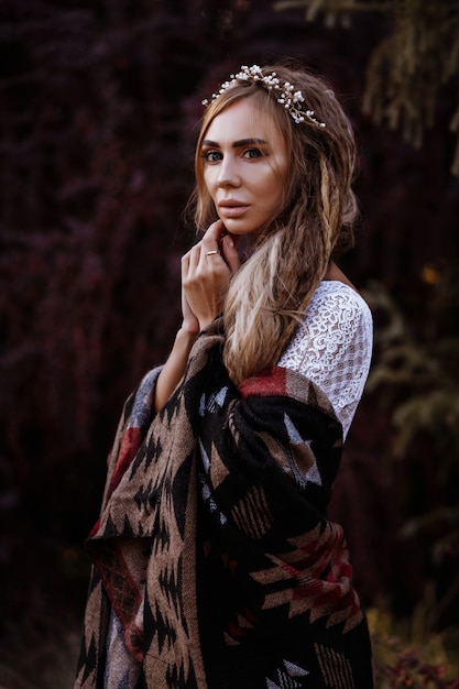 Girl with dreadlocks in poncho in summer