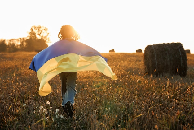 Girl with flag of ukraine running on the field patriotic girl flying ukrainian flag ukraine august