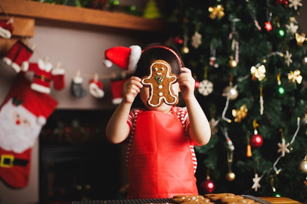 Photo girl with gingerbread cookie at home during christmas