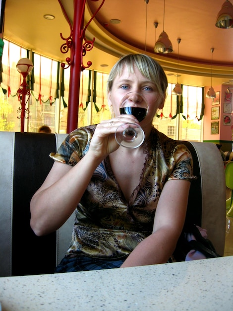 The girl with glass of red wine in restaurant