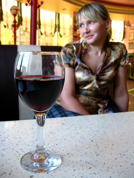 The girl with glass of red wine in restaurant