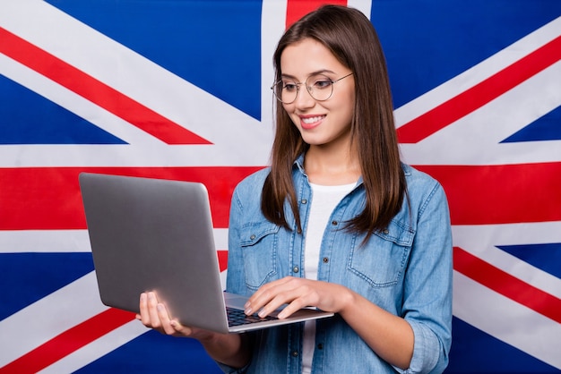 girl with glasses holds a laptop