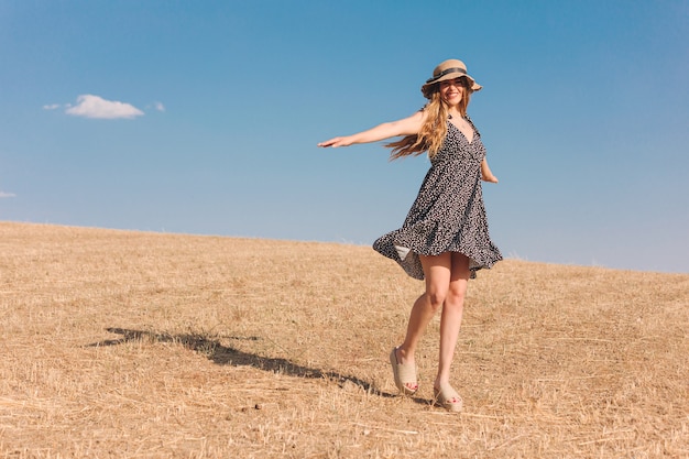 Girl with hat in a sunny summer afternoon