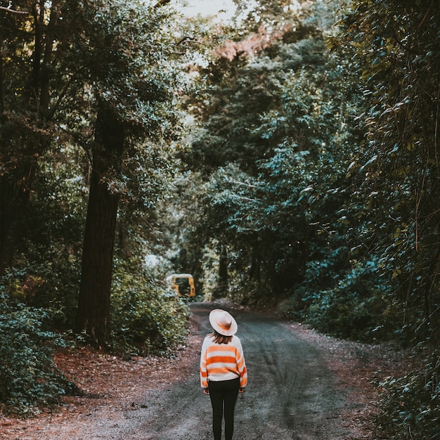 girl with hat walking in the woods