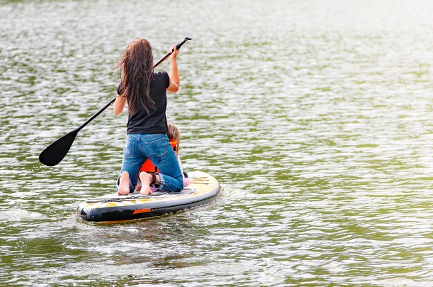 The girl with her baby stand up paddle boarding (sup)