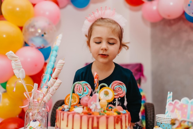 Girl with her birthday cake happy birthday carda cute little girl celebrates birthday surrounded by gifts