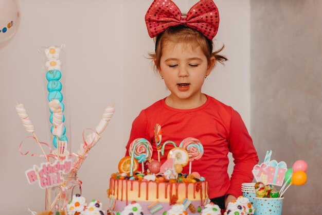 Girl with her birthday cake happy birthday carda cute little girl celebrates birthday surrounded by gifts