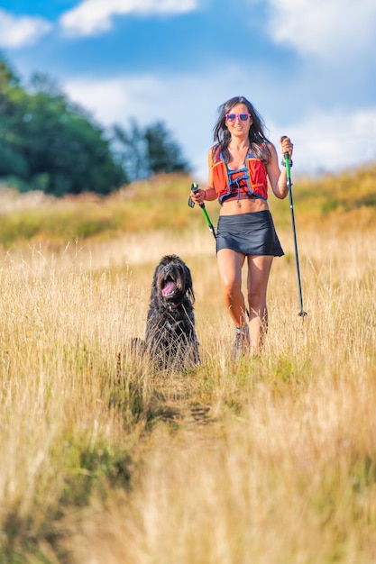 Girl with her dog on a Nordic walking trip