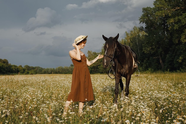 A girl with a horse a brown dress a man in nature with an animal