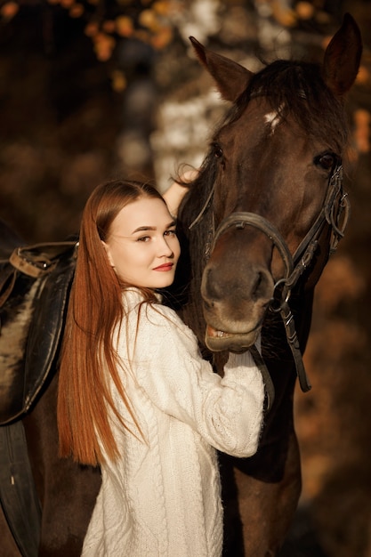 A girl with a horse in nature, an autumn walk with an animal