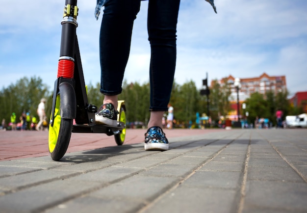 A girl with a kick scooter on the street